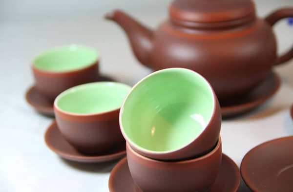 Glazed ceramic teacups in set with teapot
