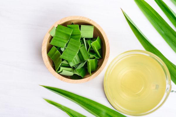 a cup of pandan tea and some pandan leaves